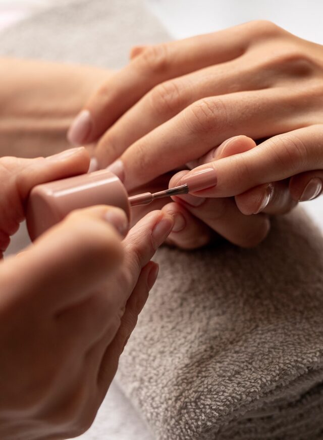 close-up-manicurist-applying-nail-polish