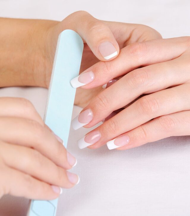 manicurist-doing-polishing-female-fingernails-with-french-manicure